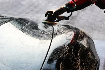 Technician hand-washing a car exterior